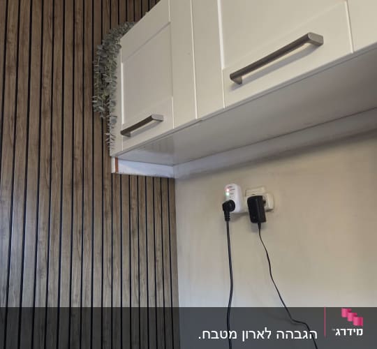 ארונות מטבח לבנים עם קיר עץ ותקע חשמלי